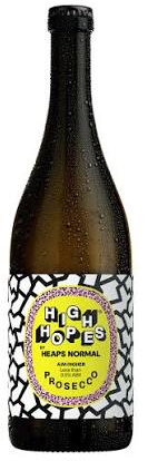 A bottle of Heaps Hope's 'Heaps Normal' Prosecco with a black cap and a black, white, and yellow label, shown against a plain white background.