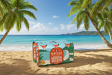 Box of Matso's Ginger Beer on a tropical beach with palm trees and clear blue water.