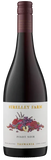 A bottle of Strelley Farm Pinot Noir red wine from Tasmania, featuring a dark glass bottle with a white label decorated with a colorful illustration of grapes and fruit, and a dark red foil at the neck.