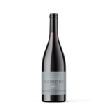 A single dark glass wine bottle with a gray label reading 'AGIORGITIKO' and 'KAMA WINEMAKERY', centered on a light gray background.